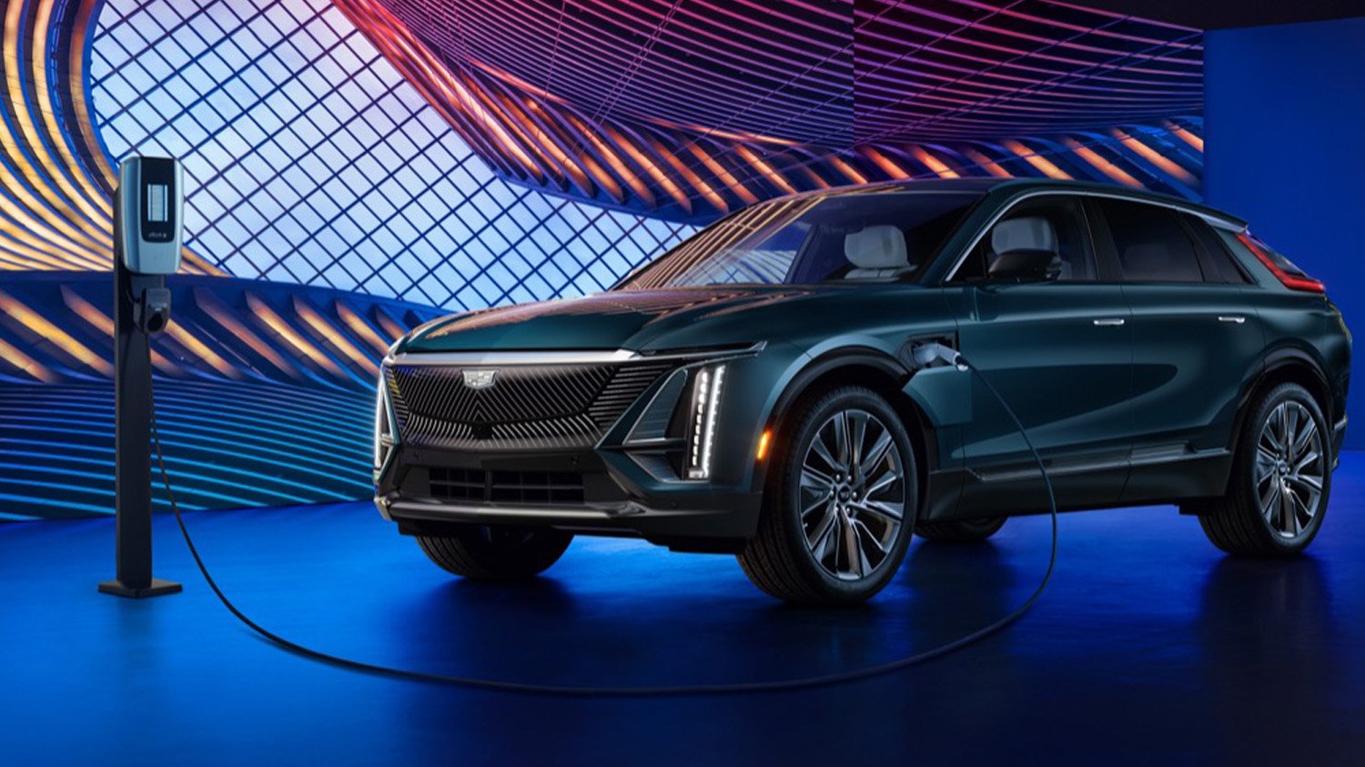 2024-Cadillac-Lyriq-Luxury-450E-Emerald-Lake-Metallic-G6I-Press-Photos-Exterior-012-side-front-three-quarters-charging